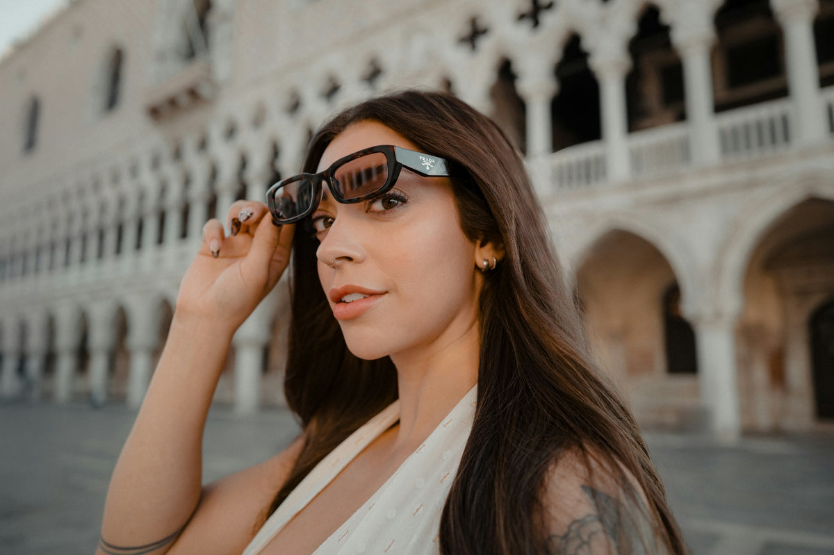 Woman adjusting her sunglasses in an Italian piazza