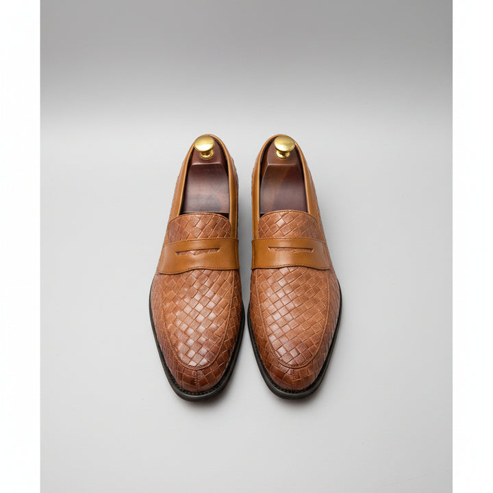 Brown woven loafers on a grid background
