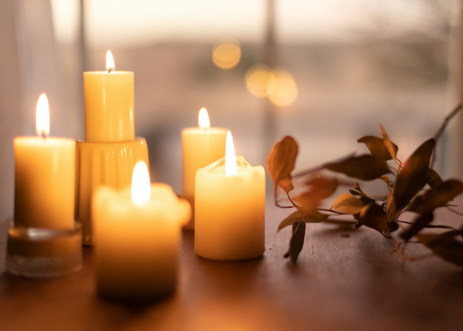 White pillar candles on a wooden table