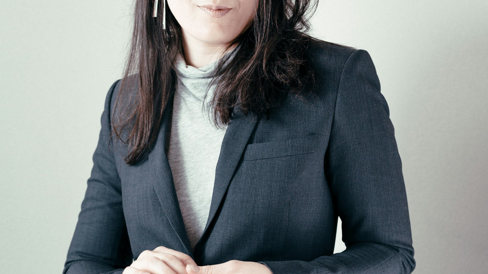 Woman in a gray turtleneck sweater under a gray blazer — how to wear a turtleneck for fall