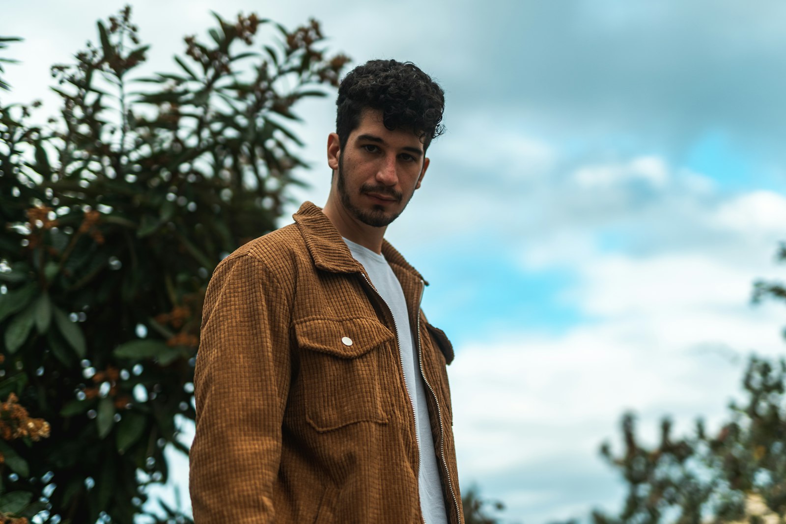 Man wearing a brown suede jacket outdoors in fall