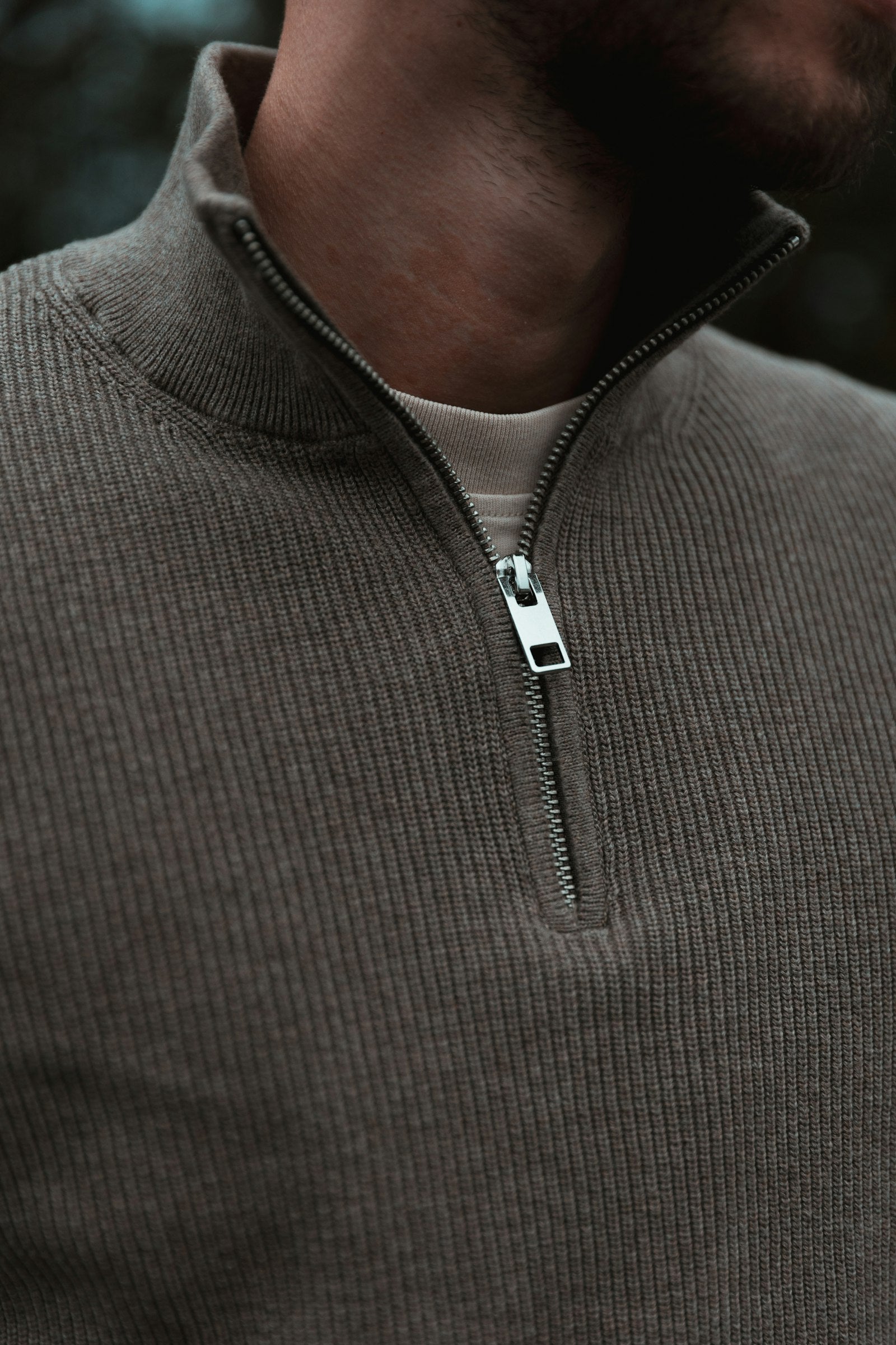 Man wearing a gray zip-neck knit sweater