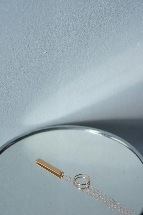 Gold chain pendant on a mirror