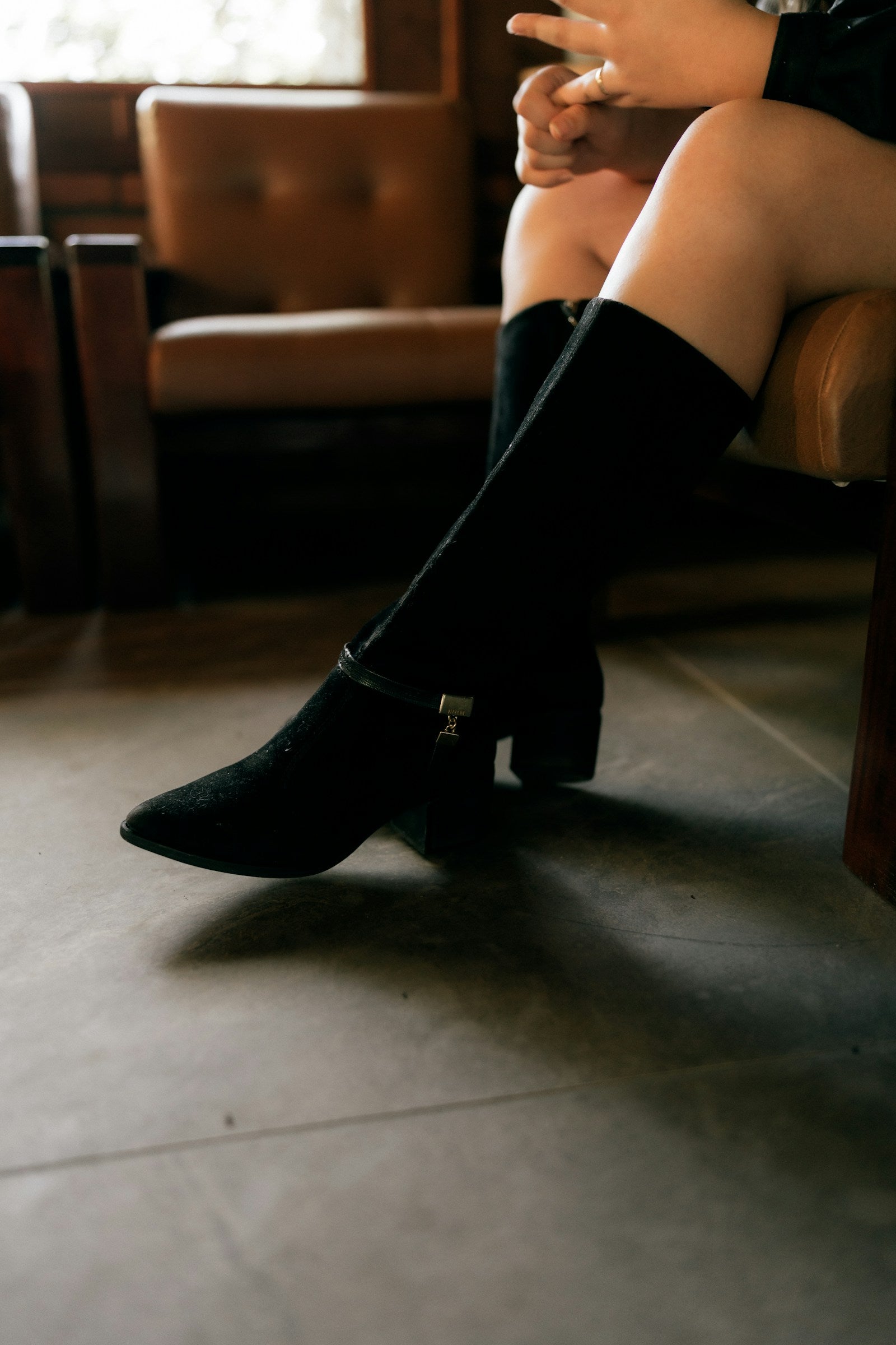 Black leather boots worn indoors in warm light