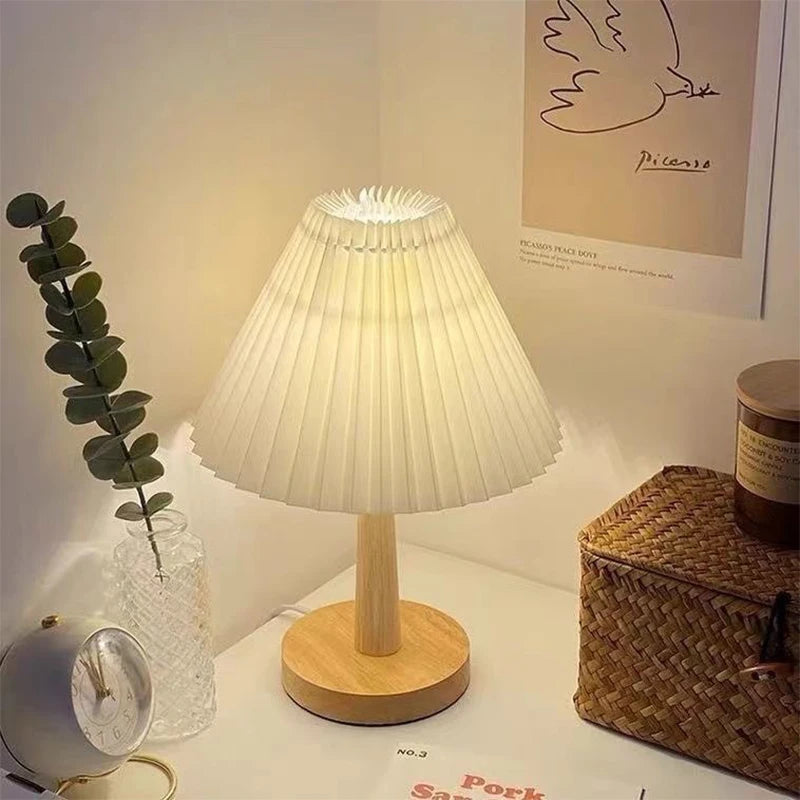 Lucciola pleated lamp on a nightstand