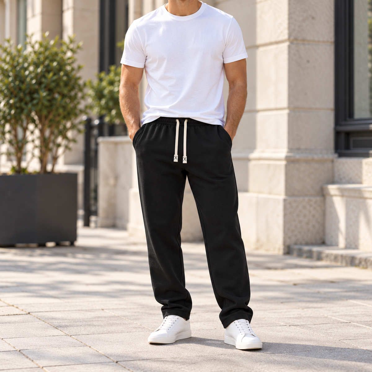 Man wearing the black Toscana fleece-lined straight-leg trousers with a white tee and white sneakers